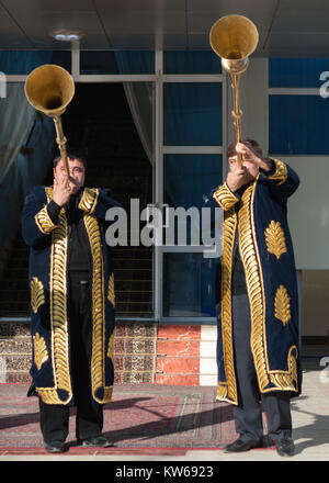 Taschkent Usbekistan - 9. Dezember 2011: Musiker Männer in traditionelle Kaftane spielen Der karnay am Eingang Stockfoto