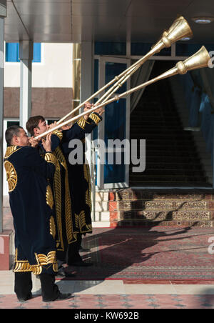 Taschkent Usbekistan - 9. Dezember 2011: Musiker Männer in traditionelle Kaftane spielen Der karnay am Eingang Stockfoto