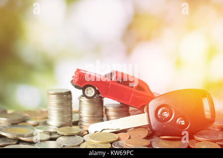 Geld Münzen mit Spielzeugauto gestapelt und auf Grün bokeh Hintergrund, Konzept, wie Kauf und Verkauf von Fahrzeugen Stockfoto