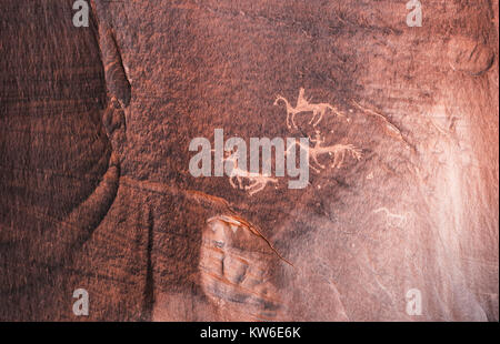 Geschnitzte Anasazi Petroglyphen, die zwei Reiter Jagd ein Tier im Canyon de Chelly National Monument, Chinle, Arizona, USA auf Rotwild Stockfoto