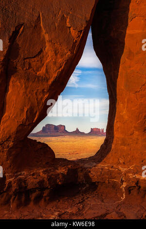 Die saddlerock ans Stagecoach Buttes durch den Tropfenförmigen Arch im Monument Valley Navajo Tribal Park gesehen vor Sonnenuntergang, Utah, USA. Stockfoto