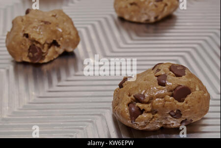 Eine Nahaufnahme von raw Chocolate Chip Cookie Dough, rollte in die Kugeln auf ein Backblech Stockfoto