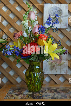 Glas Vase überfüllt mit frisch geschnittenen Garten Blumen einschließlich Dahlien, Lilien und Rosen. Stockfoto