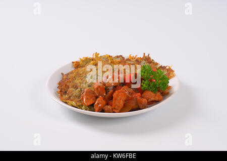 Platte von Kartoffelpuffer mit würzigen Hähnchen braten Rühren Stockfoto