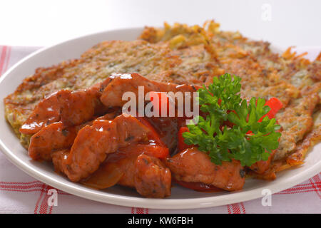 Platte von Kartoffelpuffer mit würzigen Hähnchen braten Rühren Stockfoto