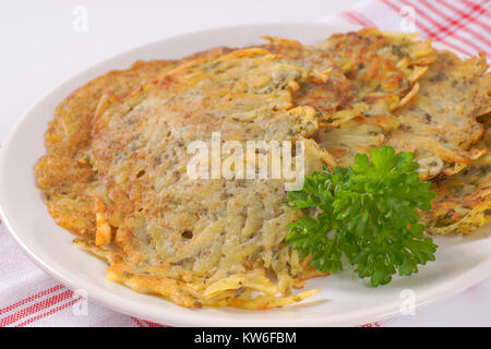 Frisch gebackene Kartoffelpuffer auf karierten Geschirrhandtuch - Nahaufnahme Stockfoto