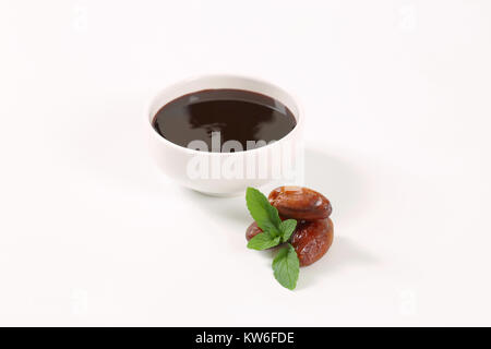 Schüssel Datum Sirup mit Termine auf weißem Hintergrund Stockfoto