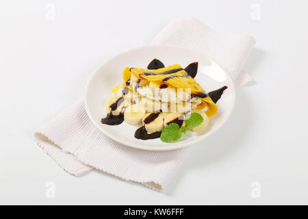 Crepes mit Bananenscheiben, Schlagsahne und Schokoladensauce Stockfoto