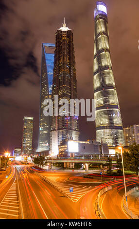 LujiaZui Financial Center - eine Nacht Blick auf den Verkehr durch die Straßen fließen an der Basis der drei höchsten Wolkenkratzer in der Mitte des Lujiazui, Shanghai. Stockfoto