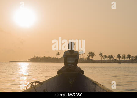 Ein Mann sitzt in einem Boot auf eine Reise auf der Volta River, Ada Foah, Greater Accra Region, Ghana, Afrika Stockfoto