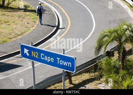 Junger Mann vorbei gehen. ein Schild in Richtung Kapstadt Südafrika. Dezember 2017. Stockfoto