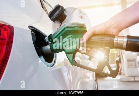 Füllen Sie das Auto mit einer weiblichen Hand auf einer Tankstelle mit Kraftstoff Stockfoto