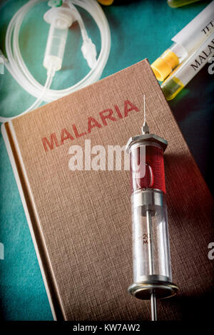 Vintage Spritze auf einem Buch von Malaria, medizinisches Konzept Stockfoto