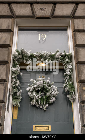 Dekorative Weihnachten Kranz an der vorderen Tür des georgianischen Stadthaus, Queen Street, Edinburgh, Schottland, Großbritannien, mit der Nummer 19 auf Oberlicht Stockfoto