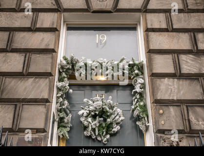 Dekorative Weihnachten Kranz an der vorderen Tür des georgianischen Stadthaus, Queen Street, Edinburgh, Schottland, Großbritannien, mit der Nummer 19 auf Oberlicht Stockfoto