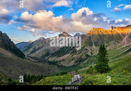 Berg Tal in Abend. Letzte Sonnenstrahlen fallen auf Cumuluswolken und oberen Kante im Vordergrund. Ostsajan. Russland Stockfoto