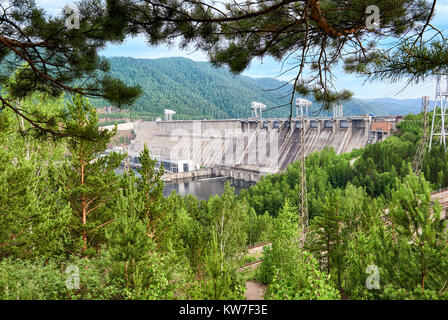 Dam ist eine leistungsstarke Sibirischen Wasserkraftwerk durch grüne Zweige der Wald. Krasnojarsk. Ostsibirien. Russland Stockfoto