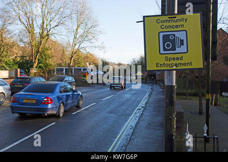 Ein Anliegen der Gemeinschaft zur Durchsetzung von Geschwindigkeitsbegrenzungen kamera Schild an der Seite einer viel befahrenen Straße in England, mit vorbeifahrenden Autos. Stockfoto