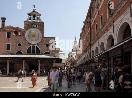 Viele Touristen und gif Geschäfte durch San Giacomo di Rialto Kirche in Venedig/Italien. Katholische gotischen Gebäude aus 1071 CE circa, mit einem großen, legendären Stockfoto