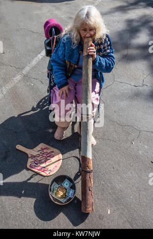 Frau spielen Didgeridoo im Santa Barbara, California's Bauernmarkt. Das Didgeridoo (auch bekannt als didjeridu) ist ein blasinstrument. Stockfoto