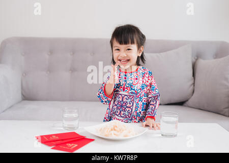 Vietnamesische kleine Mädchen in Ao Dai traditionelle Kleidung, feiern das neue Jahr zu Hause. Tet Holiday. Stockfoto