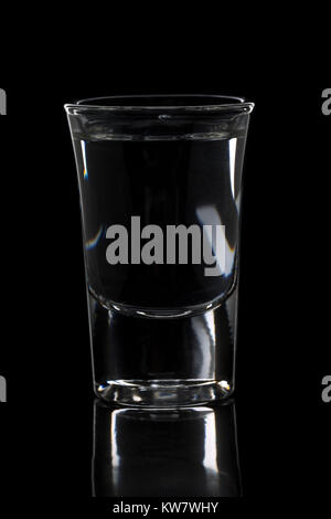 Deutschen Schnaps Korn Schnaps in shot Glas auf schwarzem Hintergrund Stockfoto