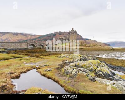 Schöne Dämmerung über Loch an Eilean Donan Castle in Schottland, niedriger Wasserstand Balg steinerne Brücke. Stockfoto