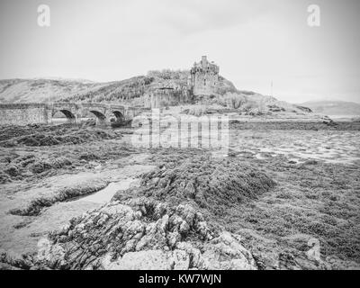 Schöne Dämmerung über Loch an Eilean Donan Castle in Schottland, niedriger Wasserstand Balg steinerne Brücke. Stockfoto