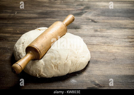 Frischen Teig mit einem Nudelholz. Auf einer hölzernen Tisch. Stockfoto