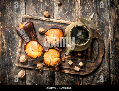 Frucht Muffins mit heißen aromatischen Tee. Auf einer hölzernen Hintergrund. Stockfoto