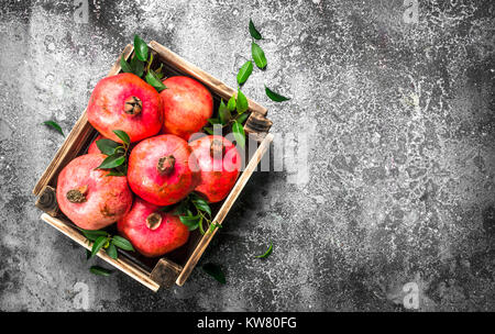 Reife granatäpfel in einer Box. Auf einem urigen Hintergrund. Stockfoto