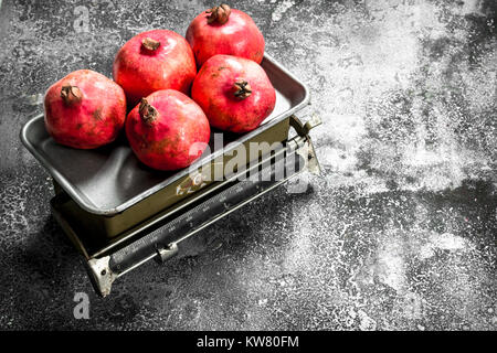 Reife Granatäpfel auf der Waage. Auf einem urigen Hintergrund. Stockfoto