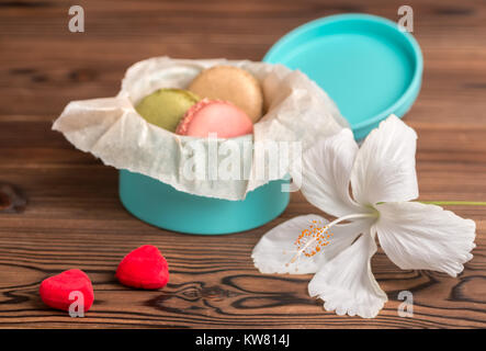 Macarons Kuchen in Geschenkbox, Paar rote Herzen und weißen Hibiskus Blume, St. Valentines Tag Konzept Stockfoto