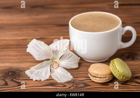 Macarons Kuchen, Kaffee und Hibiscus flower auf Holz- Hintergrund Stockfoto