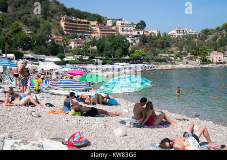 Menschen Sonnenbaden am Strand von Mazzarò, Taormina, Sizilien Stockfoto