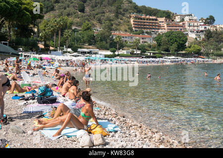 Menschen Sonnenbaden am Strand von Mazzarò, Taormina, Sizilien Stockfoto