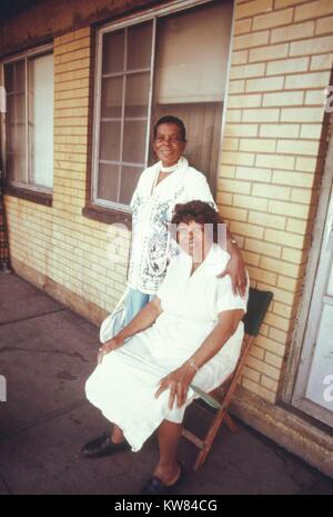 Zwei schwarze Frauen, einer in einem Stuhl, der andere steht neben ihr sitzen, auf einem der Balkone des Robert Taylor Wohnungen, geringes Einkommen Hochhaus in Chicago, Illinois, 1973. Bild mit freundlicher Genehmigung von John White/US National Archives. Mit freundlicher Genehmigung der nationalen Archive. Stockfoto