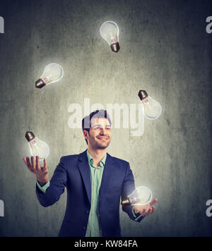 Geschäftsmann jonglieren mit brennenden Lampen in vielen tollen Ideen. Stockfoto