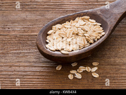 Löffel aus Holz mit Vollkorn Bio Hafer. Grob gewürfelt. Stockfoto