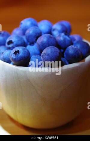 Heidelbeeren im Finnischen Holz- kuksy Schale auf einem hölzernen Schreibtisch. Nordeuropäischen noch Leben und sauber Essen Superfood. Winter 2017. Stockfoto