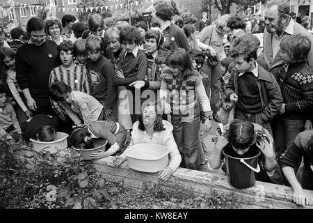 Apfelwippkinder spielen Apfeltauchen oder Apfelwippeln für Apfelwettbewerbe. Silver Jubilee Street Party 1977 Hampstead Garden Vorort. London England 1970er Jahre UK HOMER SYKES Stockfoto