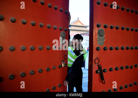 Peking, China. 31 Dez, 2017. Ein Mitarbeiter schließt das Longzong Tor in der Palace Museum in Peking, der Hauptstadt von China, 31.12.2017. Im Jahr 2017 wurde der Palast Museum erhielt Insgesamt 16,699,538 Besuche. Credit: Jin Liangkuai/Xinhua/Alamy leben Nachrichten Stockfoto