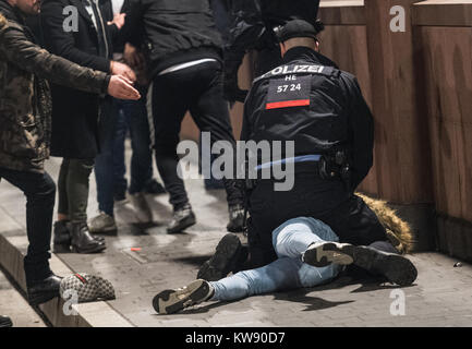 Ein Mann festgehalten wird auf dem Boden der Polizei in Frankfurt, Deutschland, 01. Januar 2018. Die Mainmetropole eine Sicherheitszone für 30.000 Besucher während der Feierlichkeiten von Silvester. Foto: Axel Heimken/dpa Stockfoto