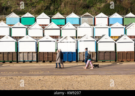 Boscombe, Bournemouth, Dorset, Großbritannien. 1.. Januar 2018. Der Neujahrstag bringt die Menschen auf einen erfrischenden Atemzug der kalten Winterluft. Für viele bedeutet dies, einfach an der Promenade entlang zu gehen, vorbei an den Reihen von Strandhütten. Stockfoto