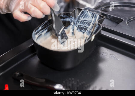 In der Nähe der Hände der weiblichen Stylist mischt Haarfärbemittel in Paint Container im Beauty Salon Stockfoto