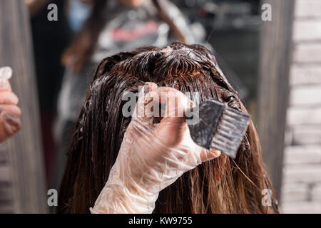 Nahaufnahme von färben Haare mit Pinsel beim Client im Stuhl im Beauty Salon sitzt. Stockfoto
