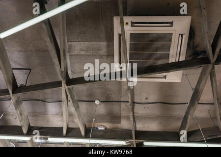 Klimaanlage in der Decke neben einer Holzkonstruktion und Lampen Stockfoto