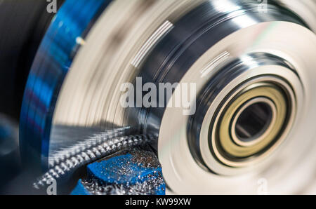 Rotierende Werkstück mit Metallspäne. Close-up geschraubt Späne beim Drehen und Werkzeug bit. Schöne Bewegungsunschärfe. Stockfoto