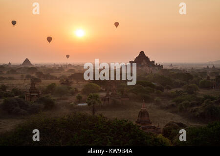 Silhouette von vielen alten Tempeln und Pagoden und vier Heißluftballons über die Ebene von Bagan in Myanmar (Burma) bei Sonnenaufgang. Stockfoto