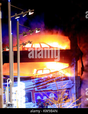 Fahrzeuge brennen während einer Flamme an einem Parkhaus in der Echo Arena in Liverpool's Waterfront. Stockfoto